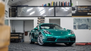 Porsche Cayman Wrapped in Avery Dennison Pearl Dark Green - Front Photo Inside the Shop