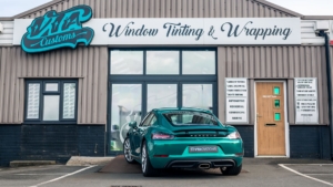 Porsche Cayman Wrapped in Avery Dennison Pearl Dark Green - Rear Photo Outside the Shop