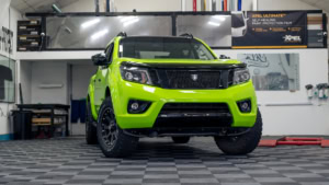 Nissan Navara wrapped in 3M's Gloss Light Green. Front photo inside the shop.