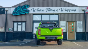 Nissan Navara wrapped in 3M's Gloss Light Green. Rear photo outside of the shop.