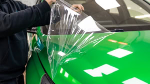 Hyundai i30N wrapped in 3M Gloss Green Envy with Gloss Black roof and side stripes. Removing the protective liner from the bonnet.