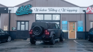 Land Rover Defender OCTA - 3M Satin Black. Rear photo from outside of the shop.